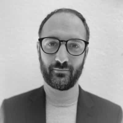 Maxime Atton - CTO of AuResources Black and white portrait of Maxime Atton, CTO of AuResources, wearing glasses and a blazer with a turtleneck.